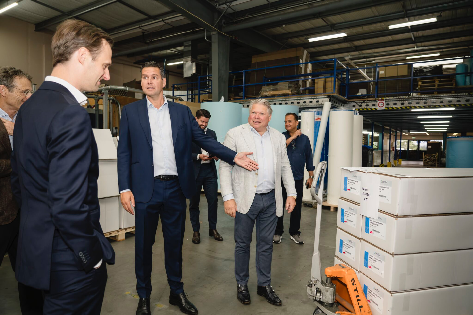 Business owner in conversation with an investor in his warehouse